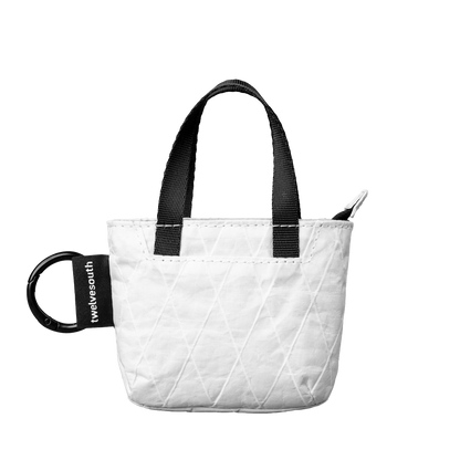 White quilted tote bag with black handles and a visible brand logo on a white background