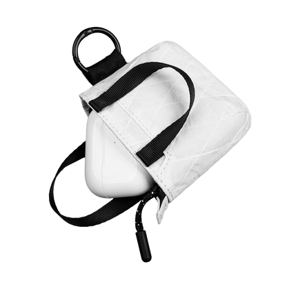 White tote with black strap on a white background and AirPods 