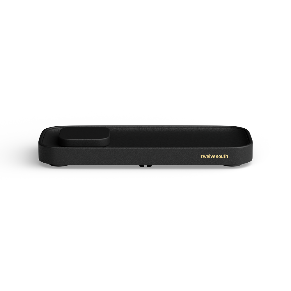 A black rectangular valet charger with rounded corners, featuring a small recessed slot on one end and the gold text 'twelve south' on the side, shown against a plain white background.